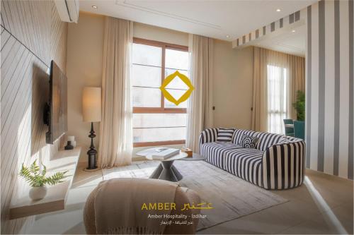 リヤドにあるAmber Hospitality - Al Izdiharのソファと窓のあるリビングルーム
