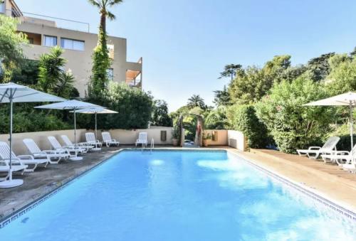 une piscine avec chaises longues et parasols dans l'établissement Appartement calme, climatisé, 15 min de la plage, Cannes la Bocca, à Cannes