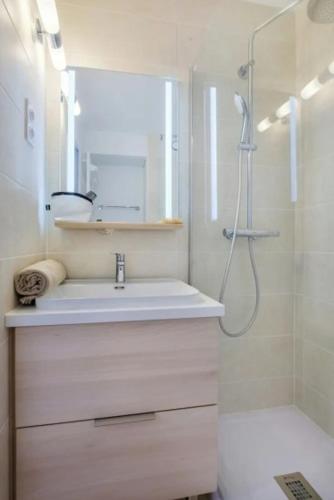 une salle de bain blanche avec un lavabo et une douche dans l'établissement Appartement calme, climatisé, 15 min de la plage, Cannes la Bocca, à Cannes