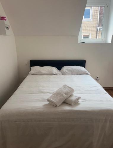 un grand lit blanc avec deux oreillers dessus dans l'établissement Royal appart city 4, à Calais