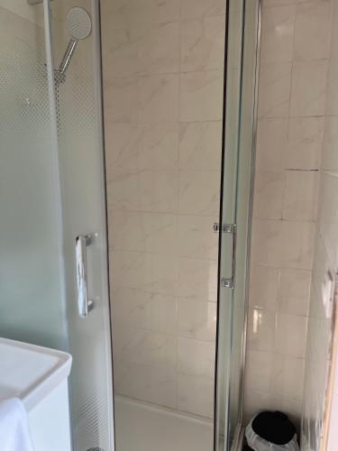 une douche avec une porte vitrée dans une salle de bain dans l'établissement Royal appart city 4, à Calais