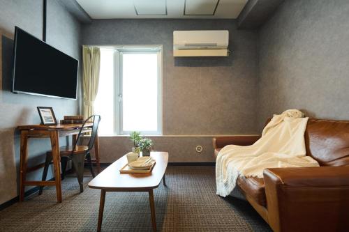 a bedroom with a bed and a table and a desk at Sapporo - Apartment - Vacation STAY 29257v in Sapporo