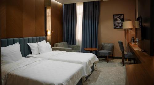 a hotel room with two beds and a desk at Green Village HOTEL & SPA in Sis