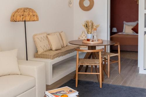 a living room with a table and a couch at Casinha Rosalia Carrasqueira in Comporta