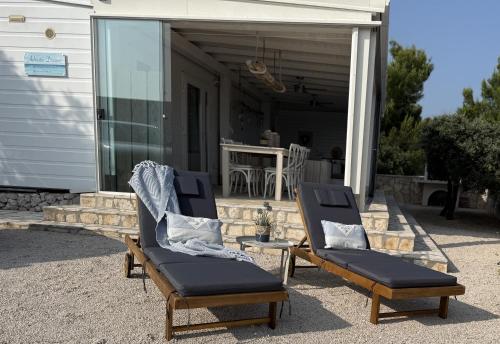 2 sillas y una mesa en un porche en Adriatic Dream - Mobile Home - Oaza Mira, en Drage