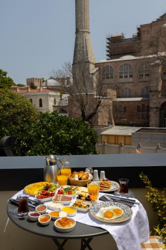 a table with breakfast food on a balcony with a tower at Hotel Saint Sophia in Istanbul