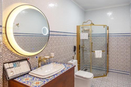 a bathroom with a sink and a mirror and a toilet at Jannat Regency Jalal-Abad in Jalal-Abad