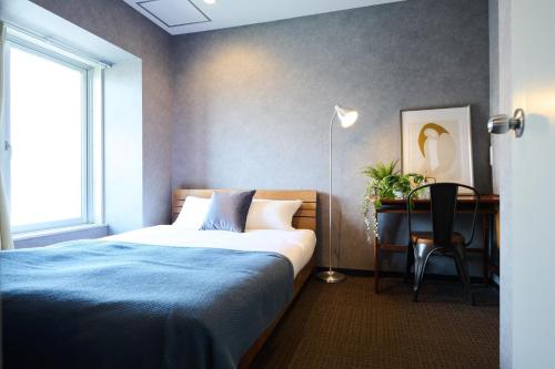 a bedroom with a bed and a desk and a chair at Sapporo - Apartment - Vacation STAY 43058v in Sapporo