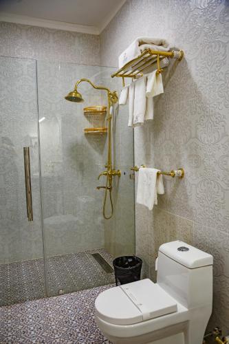 a bathroom with a toilet and a glass shower at Jannat Regency Jalal-Abad in Jalal-Abad