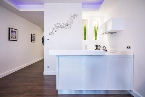 une cuisine avec des armoires blanches et un évier dans l'établissement Lifestyle Apartments, à Villingen-Schwenningen