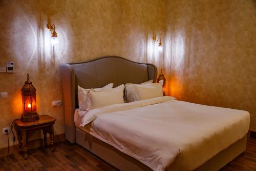 a bedroom with a bed and a lamp on a table at Jannat Regency Jalal-Abad in Jalal-Abad