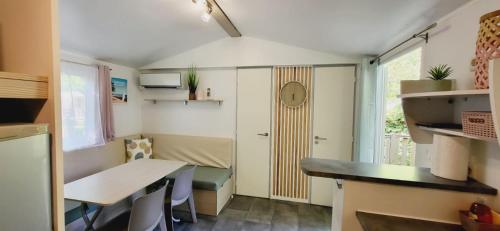 a small room with a desk and a table at Mobil Home 4 6 pers climatisé Camping Eurolac in Aureilhan