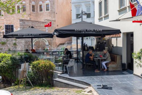 a group of people sitting at tables under umbrellas at Hotel Saint Sophia in Istanbul