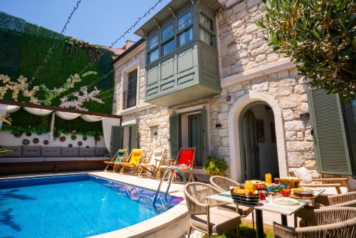 a backyard with a swimming pool and a table and chairs at The Comelly Alaçatı in Çeşme