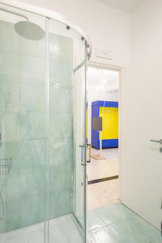 a glass shower door in a bathroom with a television at The Garden in Maiori