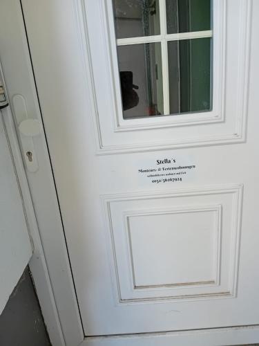 a white door with a mirror on it at Stellas Monteurwohnungen in Crimmitschau