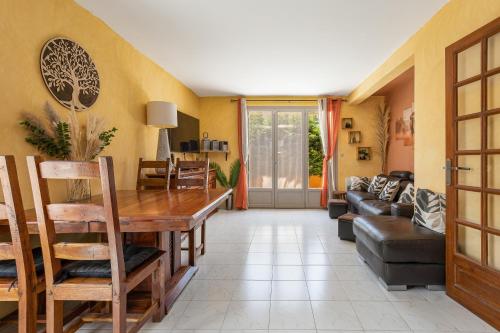 un salon avec une table et un canapé dans l'établissement La Maison Ensoleillée - Avec jardin et terrasse, à Agde
