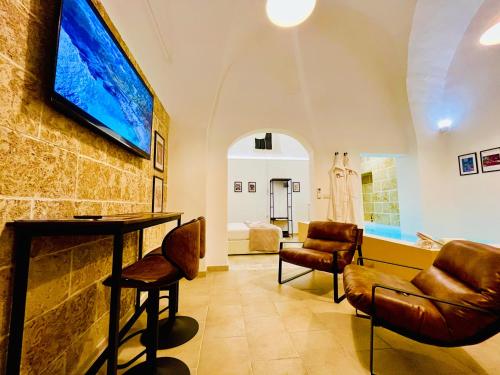 a room with a bar and a tv on a wall at Corte Gabellone - dimora storica in Nardò