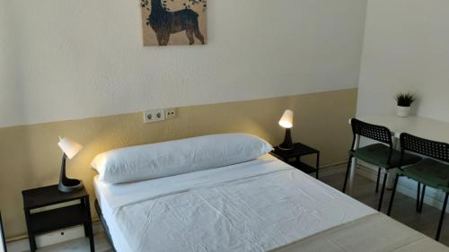 Un dormitorio con una cama y una mesa y sillas. en Usera Habitaciones A, en Madrid
