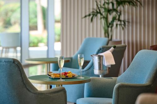 a table with a plate of fruit and two glasses of wine at Hipotels Playa de Palma Palace&Spa in Playa de Palma