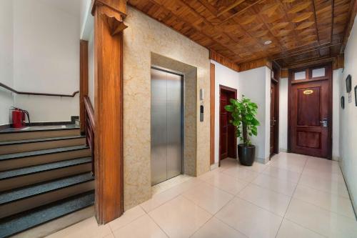 a hallway with stairs and a door with a potted plant at Truong An NoiBai Airport Hotel in Noi Bai