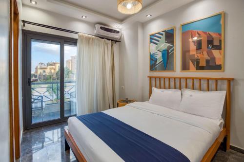 カイロにあるTravelholic AUC Residenceのベッドと大きな窓のある寝室