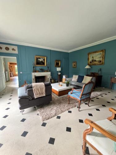 - un salon avec des murs bleus, un canapé et une chaise dans l'établissement Maison de caractère, à Tours