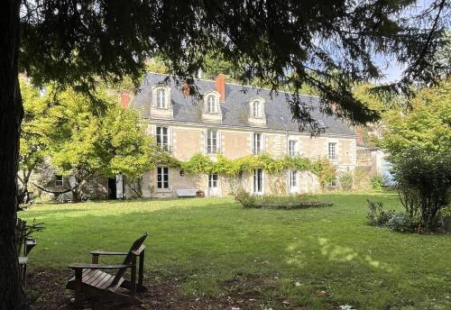 une grande maison en briques avec un banc dans une cour dans l'établissement Maison de caractère, à Tours