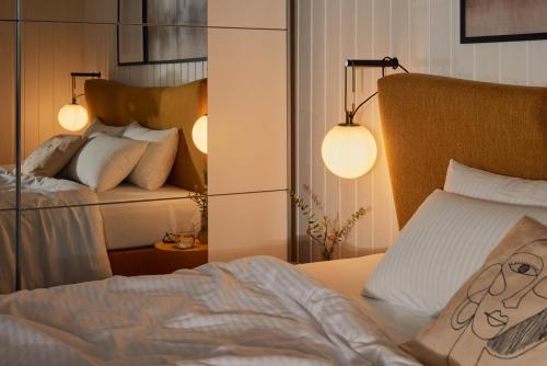 a bedroom with a bed with two lights on it at Pet-Welcoming Stay with Sauna, Style & Privacy in Wandlitz