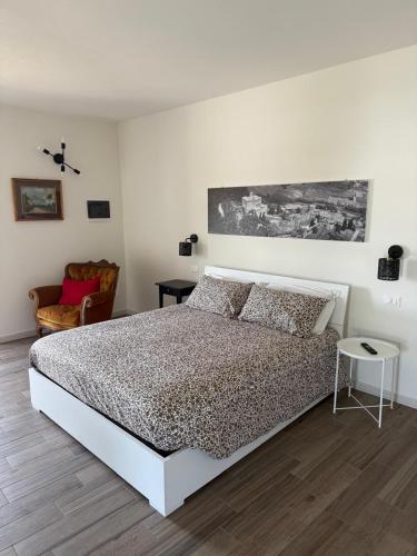 a white bedroom with a bed and a chair at Il Monastero di Qua in Sarturano