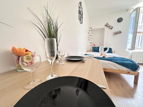 une salle à manger avec une table et des verres à vin dans l'établissement Chavalliaud 11 studio cosy en RDC proche centre, à Reims
