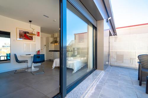 a glass door leading to a dining room with a table at Edificio Santiago by Plaza Mayor Apartamentos in Valladolid
