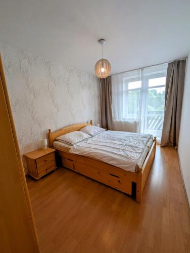 a bedroom with a large bed and a window at Apartmán Stavidlový Vrch in Vrchlabí