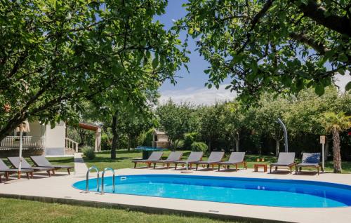 a swimming pool with lounge chairs next to a pool at Villa Ante - Makarska by Villas Guide in Gornja Glavina
