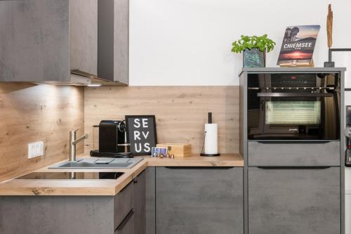a kitchen with a sink and a microwave at FENJOY Ferienapartments Bernau am Chiemsee in Bernau am Chiemsee