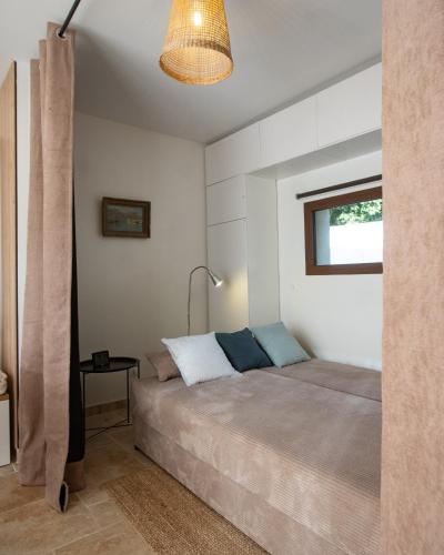 une chambre avec un lit, une lampe et une fenêtre dans l'établissement Cabanon Lourmarin, à Lourmarin