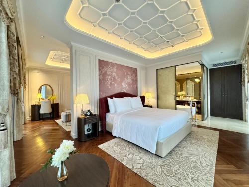 a bedroom with a large white bed in a room at Golden Sun Hotel - Dalat in Da Lat