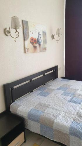 a bedroom with a bed and two lights on the wall at Грибовка,Морской Аромат in Gribovka