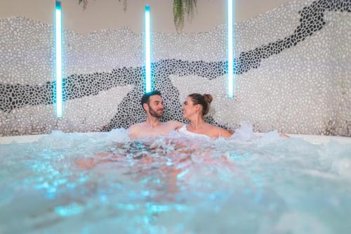 a man and a woman sitting in a hot tub at Cella Central Historic Boutique Hotel in Zell am See