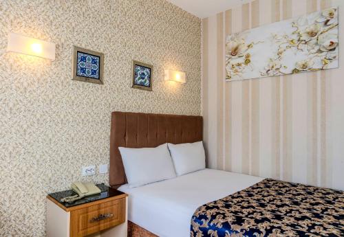 a hotel room with a bed and a phone on a table at Hamit Hotel Istanbul in Istanbul