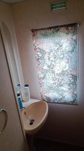 a bathroom with a sink and a painting on the wall at U Jacka za łąką in Zabiele