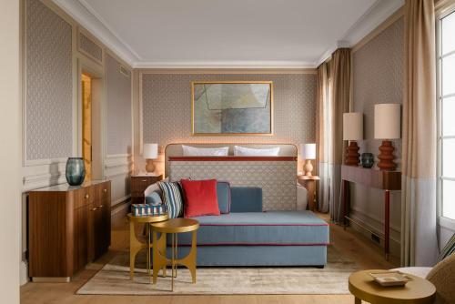 a living room with a blue couch and a bed at Althoff Hotel Villa Belrose in Saint-Tropez