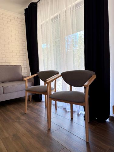 a living room with two chairs and a table and a couch at Шишка in Bukovel