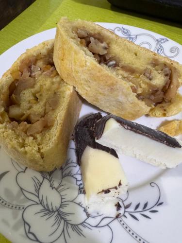 a plate with a piece of pie and a piece of cheese at Eco Village Lodge in Dzhetyoguz