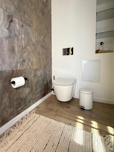 a bathroom with a toilet and a wooden floor at Шишка in Bukovel