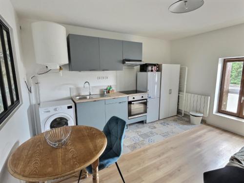 La cuisine est équipée d'une table, d'un évier et d'un réfrigérateur. dans l'établissement SUPERBE APPARTEMENT PROCHE NATURE & GARE IDEAL POUR PETITE FAMILLE ET PROFESSIONELLEs - PLUS CONFORTABLE QUE L'HOTEL!!!, à Pommeuse