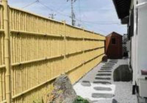 a yellow fence next to a building with a rock at 三米-鶴舞琵琶湖-biwako in Otsu