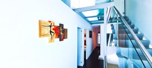 a hallway with two paintings on the side of a building at Lumen Triplex by Oshun LOFTS & MIDSTAY in Madrid