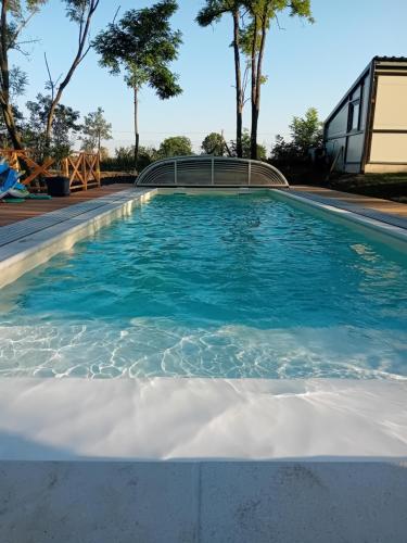 a swimming pool with blue water at Kőris Tanya in Hódmezővásárhely