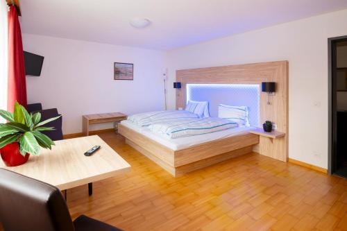 a large bedroom with a bed and a table at Hotel Schützenhaus in Uznach